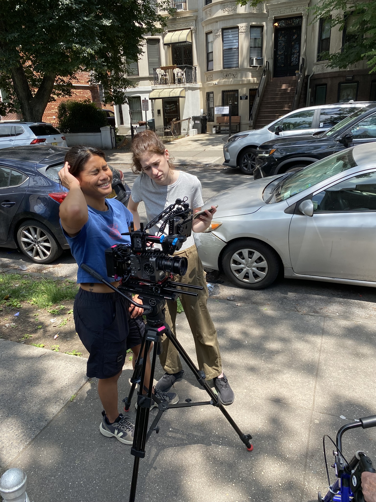 Tillie and a camera operator reviewing a shot on a Brooklyn sidewalk.